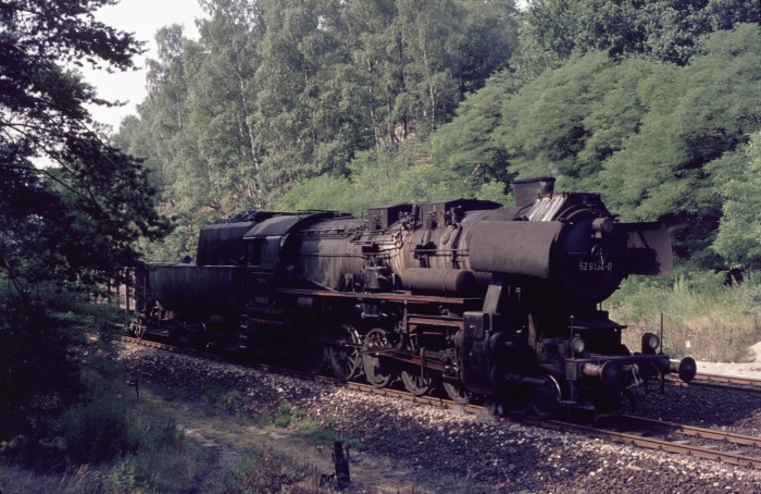 52&nbsp;8134 mit Güterzug bergauf fahrend im Wald vor Dresden-Klotzsche, 17.07.1976