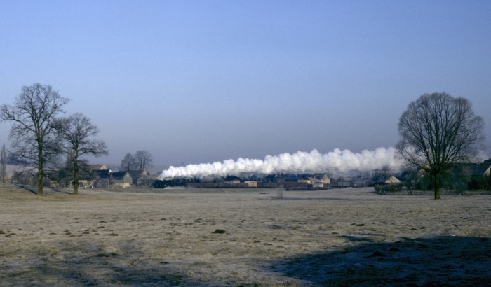 52&nbsp;8104 mit dem Durchgangsgüterzug nach Dresden (Schub: 52&nbsp;8013) an den großen Wiesen hinter Pulsnitz, am 21.02.1982 um 8:25h
