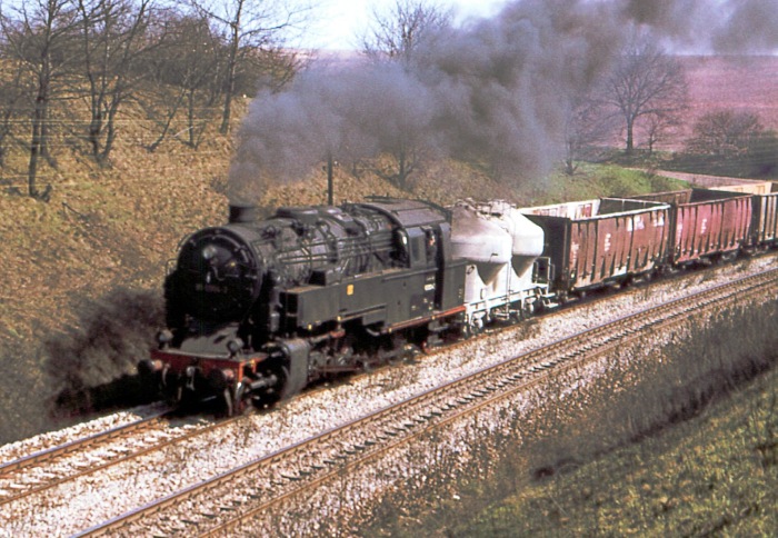 95&nbsp;0004 kommt hier mit Übergabegüterzug aus Richtung Unterwellenborn abwärts durch den bekannten Saalfelder Einschnitt gefahren, im April 1978