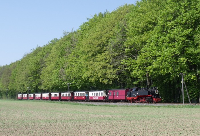 99&nbsp;2322 mit Zug von Kühlungsborn&nbsp;West nach Bad&nbsp;Doberan, fotografiert am Waldrand nördlich von Heiligendamm, zwischen Hp Steilküste und Heiligendamm, um 13:00h am 24.04.2011