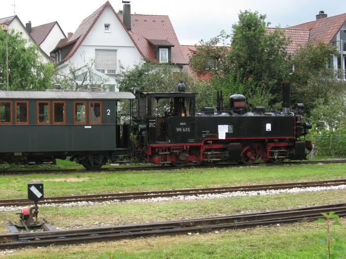 99&nbsp;633 noch kalt und teilweise ohne Treibstangen ausgestellt im Bahnhofsbereich von Ochsenhausen, mit angeklebter / plakatierter Absicht und Hoffnung, die Lok nach kompletter Aufarbeitung wieder in Betrieb zu setzen, um 13:30h am 09.08.2007 fotografiert