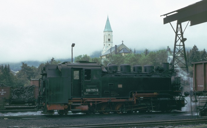 099&nbsp;737 (99&nbsp;772) im Bw Oberwiesenthal, im Hintergrund die markante Kirche des Ortes, um 15:10h bei leider ziemlich unfotogenem Wetter am 12.09.1993