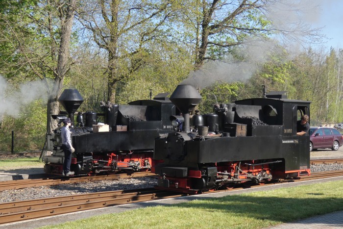 99&nbsp;3315 kommt nun ebenfalls vorgefahren, um vor den Zug Richtung Kromlau gekuppelt zu werden, begegnet dabei der 99&nbsp;3317, die gerade am vordersten Bahnsteiggleis an den Zug nach Muskau heran rollt, um 9:44h am 20.04.2025
