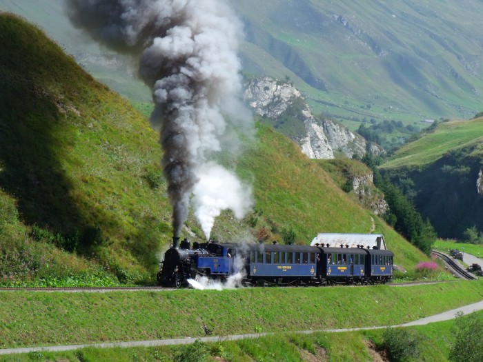 DFB&nbsp;1 mit erstem Zug des Tages von Realp nach Oberwald, fotografiert und akustisch aufgenommen am Beginn des Zahnstangenabschnitts (weit hinten auf dem Foto sichtbar!), kurz vor den Brücken über die Furkareuss (Straße und Bahn direkt nebeneinander), um 10:29h am 22.08.2014