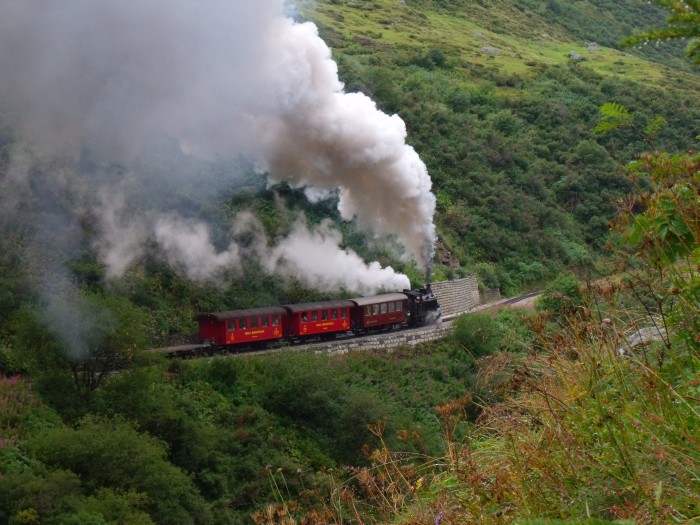 FO&nbsp;4 mit dem zweiten Zug des Tages von Realp Richtung Furka hoch (-Gletsch), am Berghang des Furkareuss-Tales oberhalb der Wilerbrücke, um etwa 11:23h am 24.08.2014