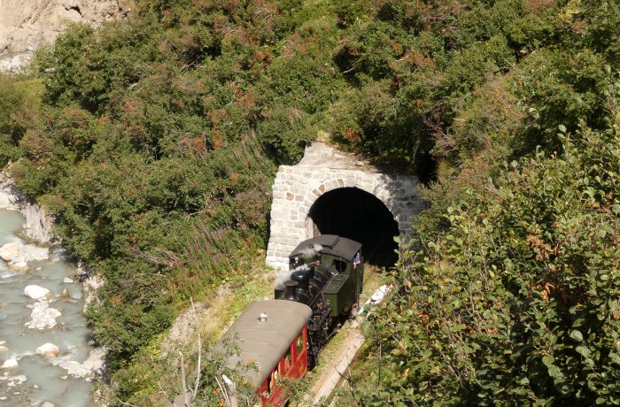 Lok 704&nbsp;Tv vor dem Zug Nr.154 Richtung Realp am oberen Tunnelportal Alt-Senntumstafel-Tunnel&nbsp;III, um 15:44h am 12.08.2022