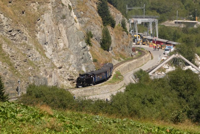 FO 4 mit Zug 157 nach Oberwald in den Kurven an den Felshängen neben der Straße hinter dem DFB-Werkstattgelände, um 14:24h am 13.08.2022