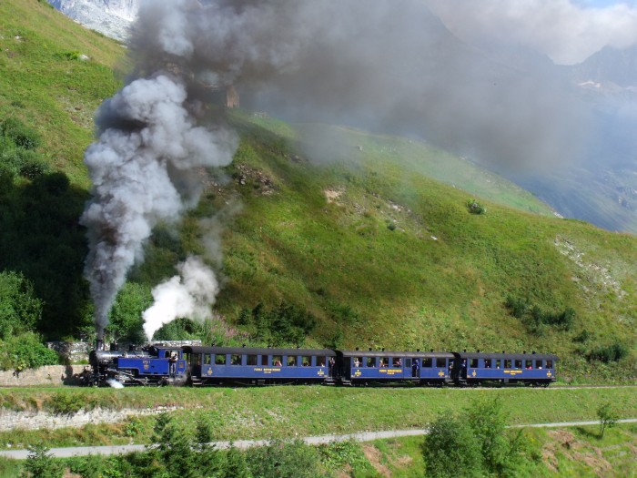 DFB&nbsp;1 mit erstem Zug des Tages von Realp nach Oberwald, fotografiert und akustisch aufgenommen am Beginn des Zahnstangenabschnitts (weit hinten auf dem Foto sichtbar!), kurz vor den Brücken über die Furkareuss (Straße und Bahn direkt nebeneinander), um 10:29h am 22.08.2014