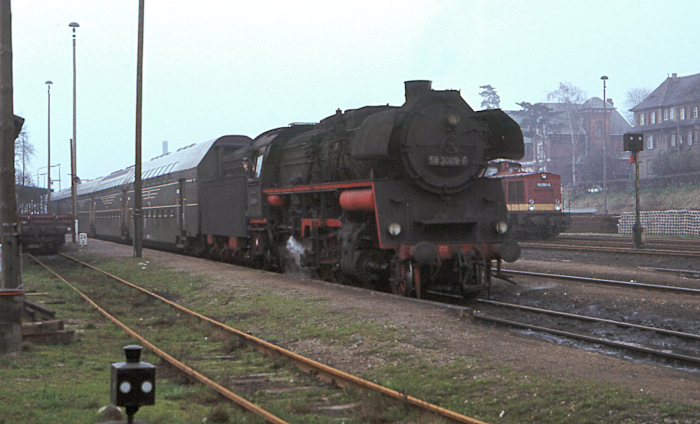 58&nbsp;3009 mit einem der dort damals zwischen Gera und Gößnitz-Glauchau üblichen Doppelstockwagen-Personenzüge, fotografiert in Ronneburg im April 1978