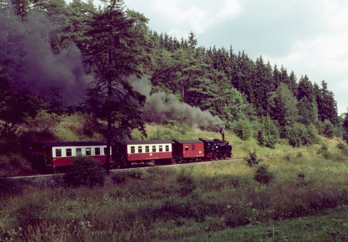 99&nbsp;5906 vor Zug&nbsp;8950 nach Herzgerode, kurz hinter dem Bahnübergang der Bundesstraße B242 zwischen Alexisbad und Harzgerode, um 12:47h am 06.08.1999